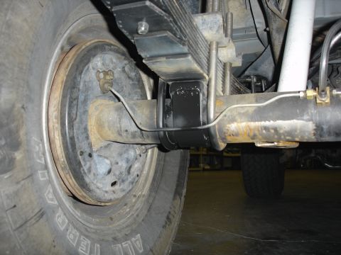 1996 Ford Bronco - This photo shows the rear axle assembly of a vehicle, including the leaf springs and brake components.