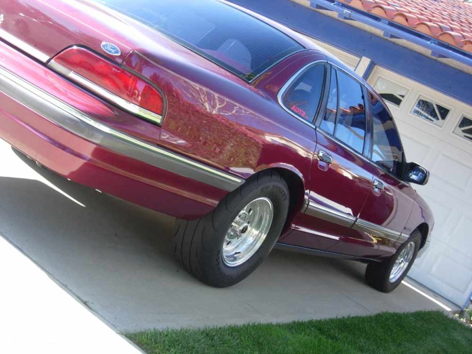 Maroon Ford Crown Victoria rear 3/4 view on polished wheels and wide rear tires
