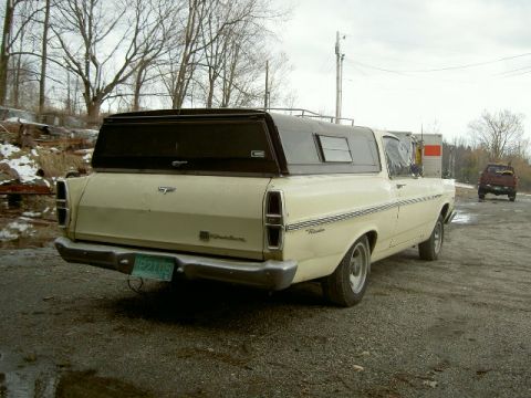 1967 Ford Ranchero - Rear view of a 1967 Ford Ranchero pickup truck with a camper shell, parked outdoors on a gravel surface.