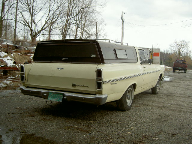 Cream 1967 Ford Ranchero rear view with camper shell and green license plate