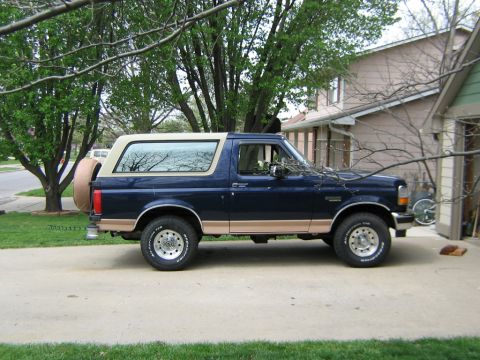 1995 Ford Bronco - This 1995 Ford Bronco is shown in a side profile, its distinctive two-tone paint scheme and a spare tire mounted on the tailgate.
