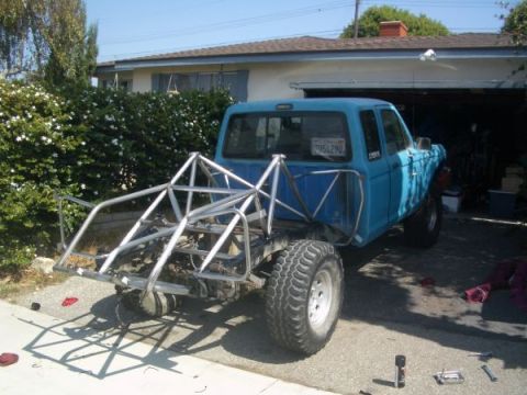 2002 Ford Ranger - A blue pickup truck, possibly modified for off-road use, is seen from the rear with a prominent custom roll cage structure.