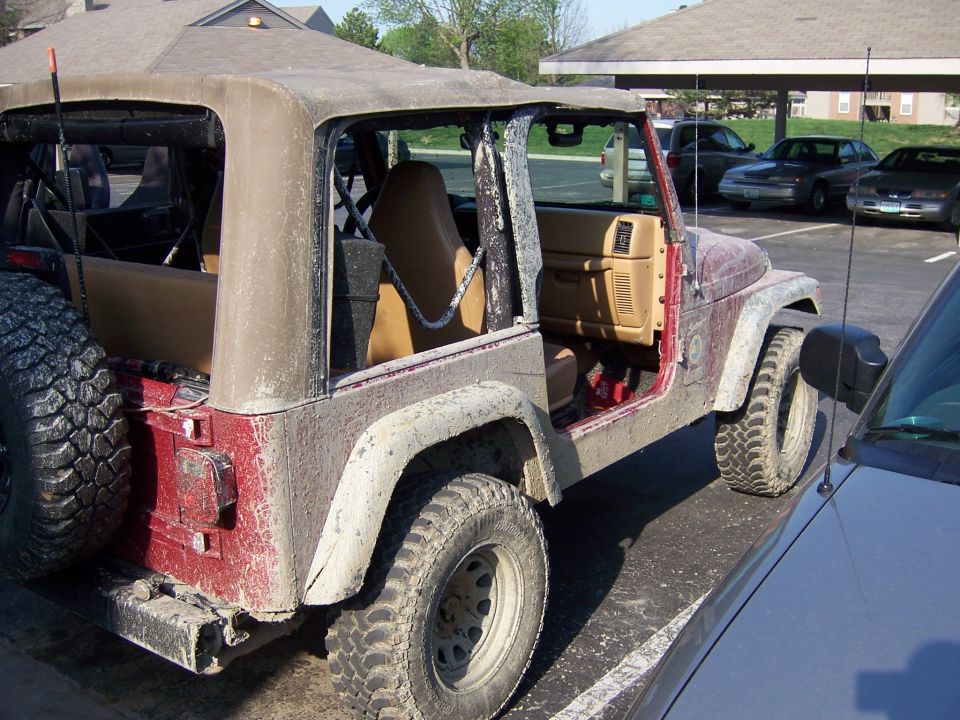 Red 1998 Jeep TJ with soft top removed, seen from 3/4 front