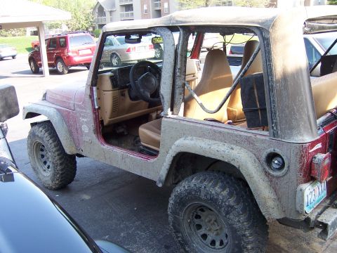1998 Jeep TJ - This 1998 Jeep TJ is covered in mud, showing its off-road use. Doors are off.