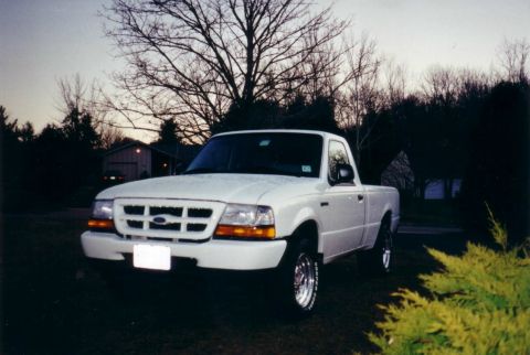 1987 Ford Bronco - A white Ford pickup truck is parked on a lawn during twilight.