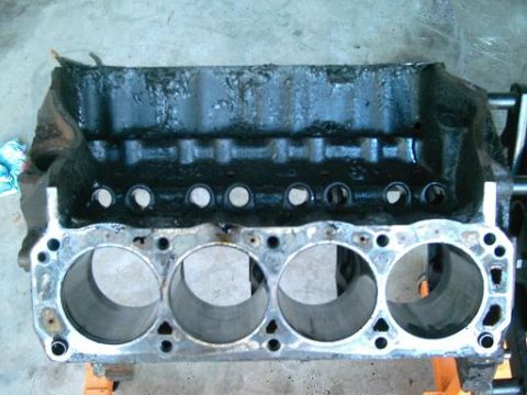 1986 Ford Bronco - Engine block with four cylinders visible, covered in black grime.