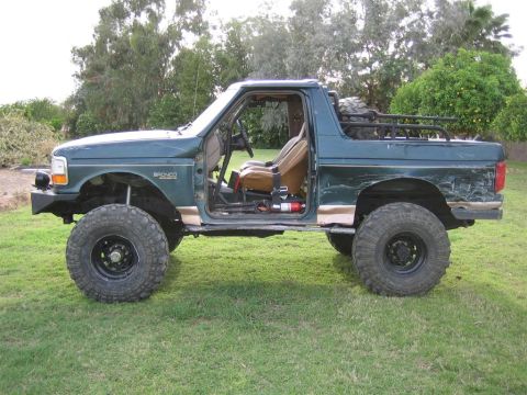 1994 Ford Bronco - This modified Ford Bronco features an open-air design with removed doors and a roll cage.