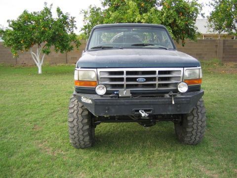 1994 Ford Bronco - This Ford Bronco features a custom front bumper with a winch and auxiliary lights, along with off-road tires.