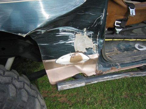 1994 Ford Bronco - Close-up of significant body damage to a vehicle's door and fender area.