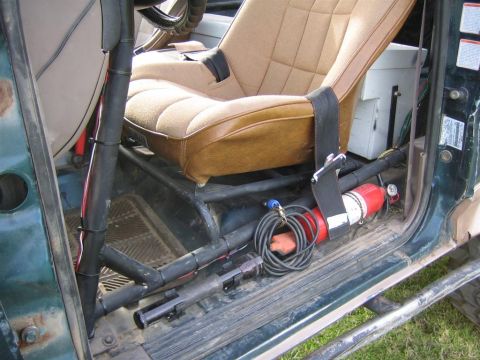 1994 Ford Bronco - The interior of a 1994 Ford Bronco shows a roll cage, racing seat, and a mounted fire extinguisher.