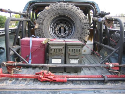 1994 Ford Bronco - The bed of a green 1992 Ford Bronco is filled with off-road equipment, including a spare tire, ammo cans, and a Hi-Lift jack.