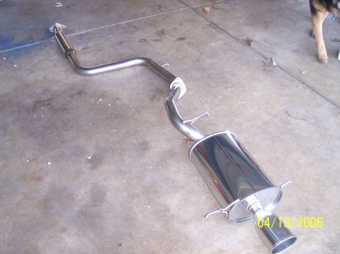 1995 Ford Probe - Aftermarket exhaust system part laid out on a concrete surface with a watermark indicating the date and website.