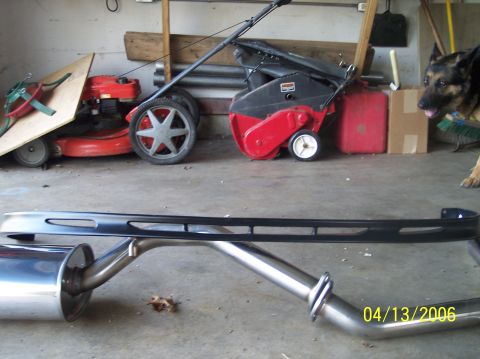1995 Ford Probe - A chrome exhaust system and black bumper are displayed in a garage setting.