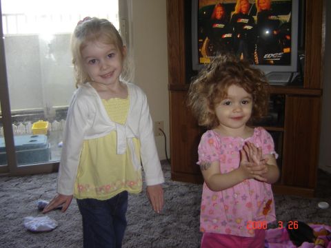 1993 Ford Bronco - Two young girls pose in a living room, with a television displaying a group of women in the background.