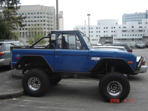 1993 Ford Bronco - This lifted blue Ford Bronco, seen from the side, features a roll cage and appears to be from the 1978 model year.