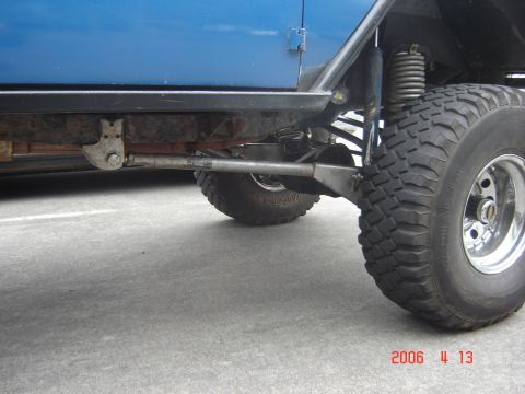 1993 Ford Bronco - Modified suspension components and a large off-road tire are visible on a blue vehicle.