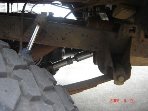 1993 Ford Bronco - The underside of a vehicle shows its suspension system, including a shock absorber and leaf spring.