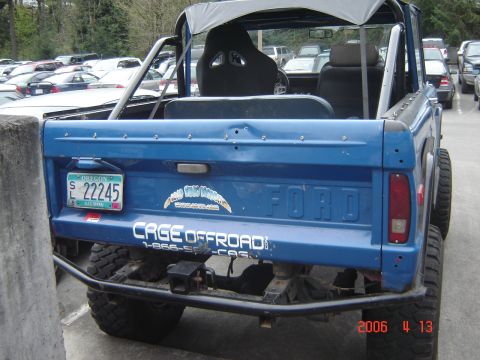 1993 Ford Bronco - Blue Ford Bronco with off-road modifications parked in a lot with other vehicles.