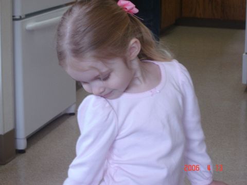 1993 Ford Bronco - A young girl with a pink bow in her hair looks down while standing indoors.