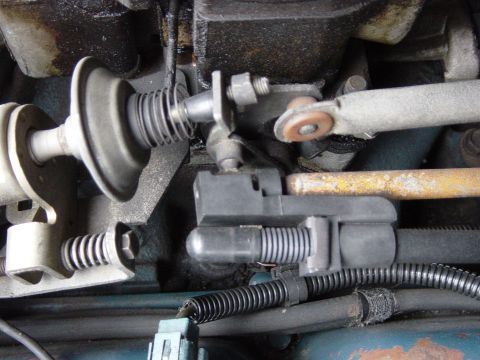 1982 Ford Crown Victoria LTD - Close-up of a vehicle's carburetor linkage, showing various mechanical components and wiring.
