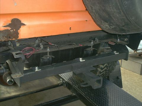 1978 Ford Bronco - Close-up view of the rear bumper and trailer hitch assembly on an orange vehicle.