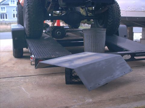 1978 Ford Bronco - Vehicle's rear axle and tires are visible as it sits on a trailer. A metal ramp is in front.