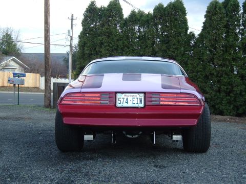 1976 Pontiac Firebird - Rear view of a 1976 Pontiac Firebird, red paint, racing stripes, and wide rear tires.