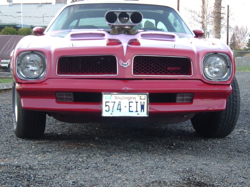 Front of red Pontiac Firebird with chrome blower through hood, Washington plate 574-EIW