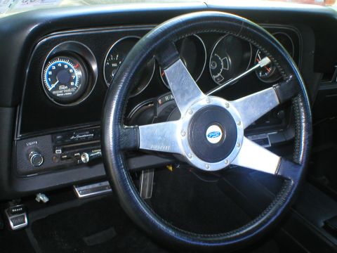1973 Ford Ranchero - The interior of a 1973 Ford Ranchero shows a tachometer, radio, and a Ford-branded steering wheel.