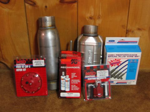 1995 Ford Bronco - A collection of automotive performance parts are displayed against a wood-paneled background.