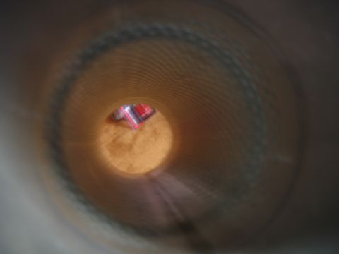 1995 Ford Bronco - View from inside an exhaust pipe shows a red and silver object in the distance.