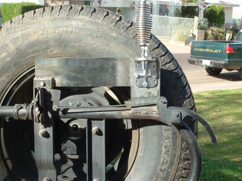 1990 Ford Bronco - Custom spare tire mount and CB antenna assembly, with a Chevrolet pickup visible in the background.