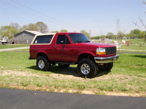 1989 Ford Bronco - This lifted 1989 Ford Bronco features a two-tone paint scheme with a red body and tan removable top.