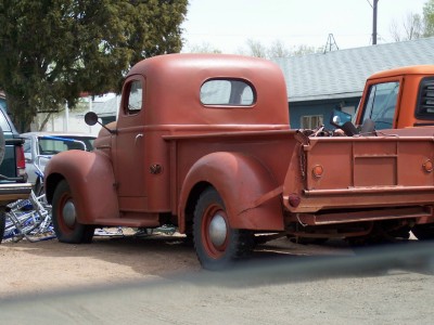 1972 Ford Ranchero - A vintage red pickup truck is parked outdoors next to another vehicle.