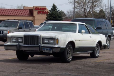1972 Ford Ranchero - A white coupe with a dark green roof and lower body is parked in a lot, with other vehicles nearby.