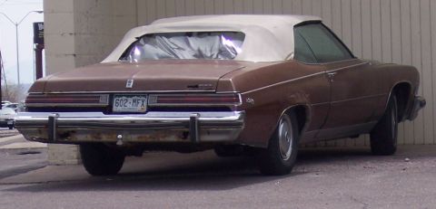 1972 Ford Ranchero - This brown convertible features a white top and a rear view showing the license plate 602-MFX.