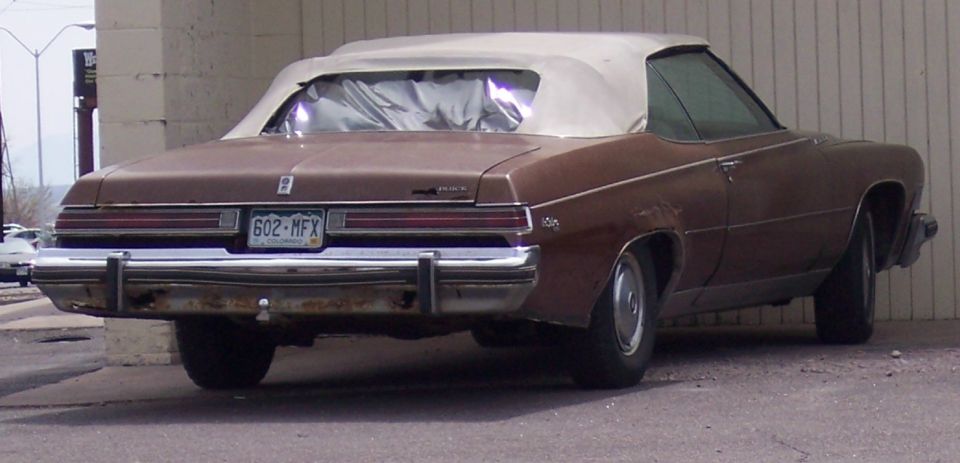 Brown convertible with white top, rear view. License plate 602-MFX