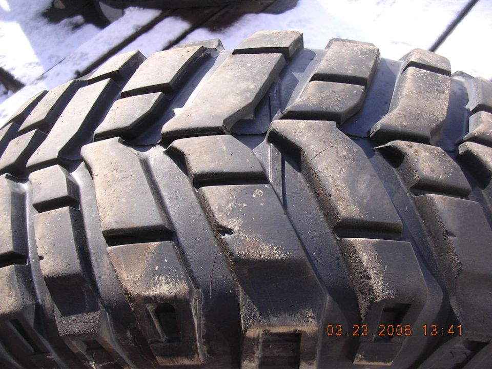 Close-up of a worn, black off-road tire tread with large, blocky lugs. Date stamp 03.23.2006 visible
