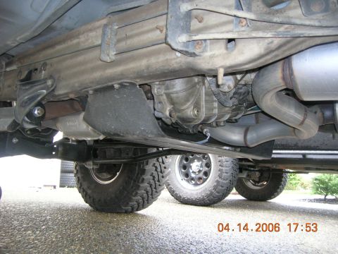 1996 Ford Bronco - A view of the undercarriage, focusing on the exhaust system and drivetrain components, with two tires visible.