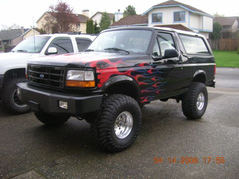 1996 Ford Bronco - This lifted 1996 Ford Bronco features custom flame graphics on its black paint.