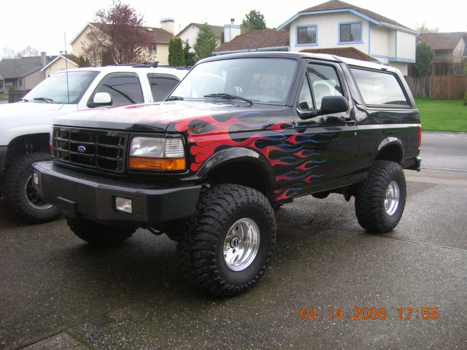 Black 1996 Ford Bronco with flame graphics, lifted with large tires