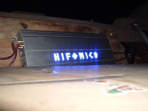1994 Ford Thunderbird - A car amplifier with a glowing blue 'HIFONICS' logo is visible, mounted within a wooden enclosure.