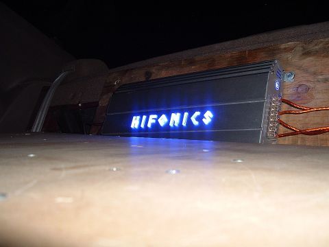 1994 Ford Thunderbird - Car audio amplifier with illuminated HIFONICS logo is mounted on wooden panels.