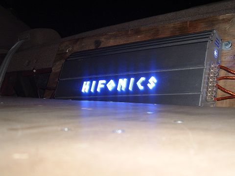 1994 Ford Thunderbird - A car amplifier with a glowing blue Hifonics logo is installed in a wooden enclosure.