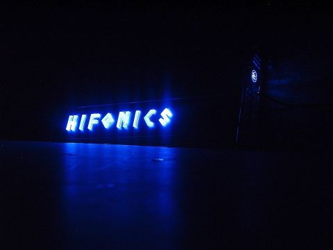 1994 Ford Thunderbird - A blue neon sign glows in the dark, reflecting on a dark surface.