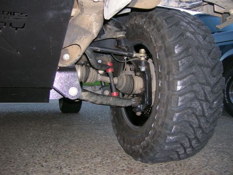 2002 GMC Yukon - Close-up view of the front suspension and a large off-road tire on a vehicle.