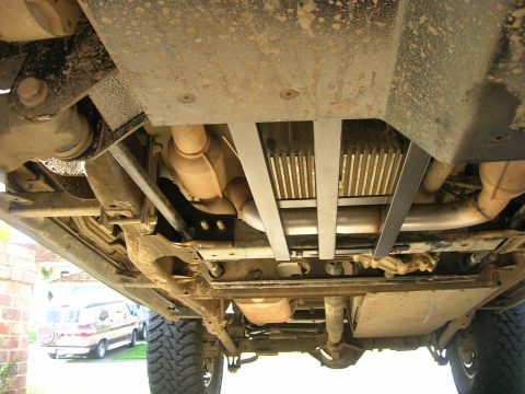 2002 GMC Yukon - Underside view of a vehicle, showing skid plates and exhaust system. Another vehicle is visible in the background.