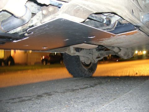 2002 GMC Yukon - The underside of a vehicle is captured, revealing its skid plate and suspension system.