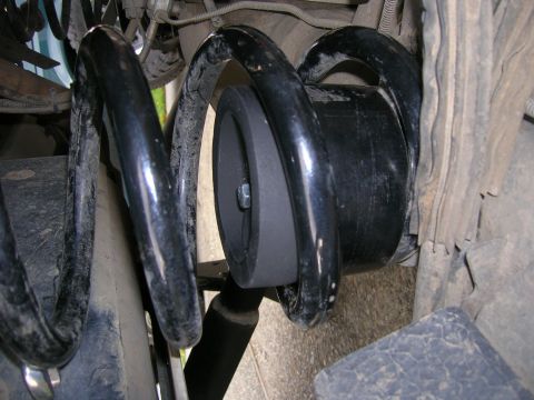 2002 GMC Yukon - Close-up of the rear suspension system on a 2002 GMC Yukon, showing the coil spring and shock absorber.