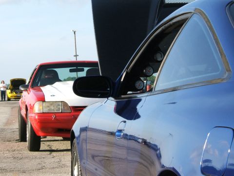 1996 Ford Probe - Two cars are lined up at a track, one red and white, the other blue.